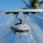 Comparativa visual de oxidación: Lámina de Zinc Galvanizado opaca frente a lámina de Aluzinc brillante en un techo costero.